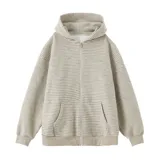 Campera con capucha y cierre frontal, color hueso con rayas finas horizontales en tono oscuro. Presenta un calce holgado (boxy fit) y puños y cintura acanalados.