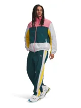 Campera deportiva Under Armour con cierre frontal completo, confeccionada en tejido ligero de nailon con textura arrugada. Presenta un diseño color block en tonos rosado, verde oscuro, blanco y amarillo, con cuello alto, bolsillos laterales con cierre y puños elásticos.
