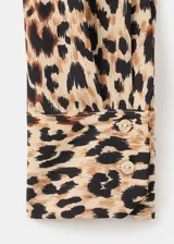 Camisa fluida de corte recto con estampado animal print de leopardo, cuello camisero, manga larga y cierre frontal con botones.