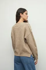 Sweater de tejido tramado en color verde oliva, con cuello redondo y mangas largas. Presenta un diseño de textura acanalada vertical.