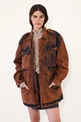 Parka oversize de jean con acabado lavado en tono óxido, de corte amplio y relajado. Presenta cuello clásico, bolsillos frontales con tapa y cierre frontal.