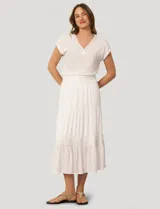 Falda larga de crepé de rayón color blanco, con diseño de paneles escalonados y detalles de puntilla. Presenta una silueta holgada y cintura elástica.