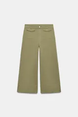 Pantalón culotte de tiro alto en color verde militar. Presenta bolsillos frontales de plastrón con solapa, cierre frontal con cremallera y botón, y diseño de pierna ancha con dobladillo marcado.