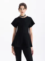 Top de tejido de punto color negro, con cuello redondo, mangas cortas acampanadas y cuerpo con diseño de tablas verticales que aportan estructura.