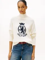 Sweater de Tommy Hilfiger confeccionado en pura lana, con cuello perkins y diseño de manga raglán. Presenta un escudo gráfico distintivo bordado en el pecho y acabados en punto canalé en cuello, puños y bajo.