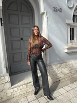 Pantalón negro de eco cuero, de tiro alto y corte recto.