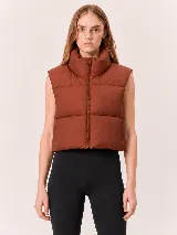 Chaleco puffer corto de diseño acolchado, con cuello alto y cierre frontal completo. Presenta un corte relajado y sin mangas.