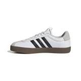 Championes Adidas modelo VL Court 3.0, de diseño urbano con base de goma vulcanizada color marrón. Presenta una parte superior de cuero sintético blanco con las icónicas tres tiras laterales en negro y detalles de gamuza en la puntera y el talón.