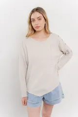 Remera manga larga color rosa con bolsillo en el pecho y corte irregular en el ruedo.