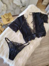 Conjunto de lencería compuesto por un top bralette y una tanga. El top presenta un diseño con escote profundo, mangas cortas de encaje y detalles de encaje en los bordes. La tanga es de corte regulable, confeccionada en lycra y encaje con forro de algodón.