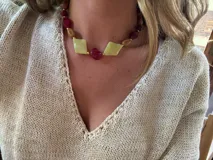 Collar corto con cuentas de piedra en tonos verde claro, rojo y marrón.