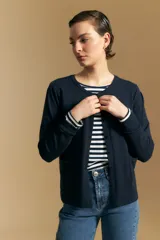 Cardigan negro de tejido suave y liviano, con cierre frontal abotonado y cuello redondo.