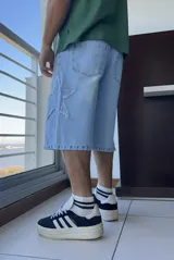 Bermuda de jean celeste, corte ancho y largo a la rodilla, con aplique de estrella en el lateral.