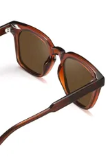 Lentes de sol con armazón de acetato biodegradable en color ámbar translúcido y diseño cuadrado ligeramente extragrande. Cuentan con lentes oscuros con protección UV 400.