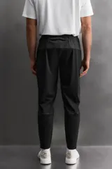 Pantalón negro de entrenamiento slim fit confeccionado en tejido técnico ligero y elástico con estructura. Cuenta con cintura elástica ajustable con cordón, bolsillos frontales y trasero con cierre de cremallera, y bajo ajustable con cremallera en laterales.