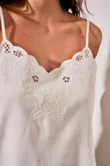 Musculosa blanca de viscosa con tirantes finos, escote en V y detalle de bordado floral con recortes en el borde superior.