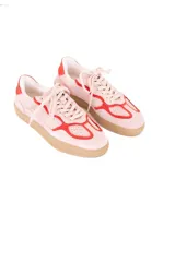 Championes de estilo deportivo vintage, confeccionados en una combinación de cuero y gamuza en tonos rosado y rojo, con suela plana de goma color caramelo.
