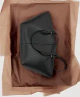 Bolso tipo shopper de efecto piel, con doble asa de hombro, cierre de botón magnético y bolsillo interior con cremallera.