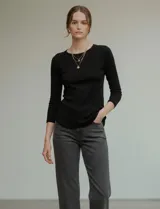 Remera de manga tres cuartos, color negro, confeccionada en modal, con cuello redondo ajustado a la base.