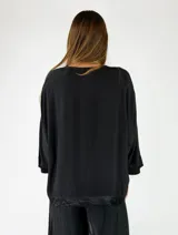 Blusa de viscosa color mostaza, con escote en V, mangas cortas holgadas y diseño amplio.