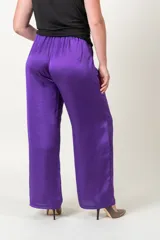 Pantalón palazzo rojo de satén con cintura elastizada y bolsillos laterales.