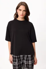 Remera básica de algodón color negro, con cuello redondo y detalle de bordado en el hombro.