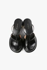 Mules de cuero color blanco con diseño moderno, taco ancho y plataforma. Cuenta con una tira superior negra que aporta estabilidad y un calce cómodo.