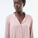 Camisón de estilo camisero color rosa, con mangas largas, cuello solapa y cierre frontal de botones. Presenta un bolsillo pequeño en el pecho y ribetes en contraste.