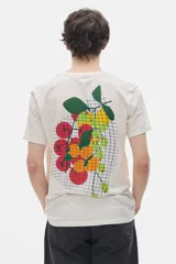 Remera color crudo de cuello redondo y manga corta, con calce oversized y estampado de frutas en la espalda.