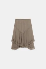Falda corta de tiro medio con cintura elástica, confeccionada en tejido de viscosa. Presenta un diseño asimétrico con volantes en el bajo.