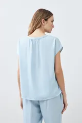 Blusa celeste de lyocell con escote en V y mangas cortas.