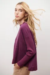 Buzo de punto color beige, con cuello redondo y manga larga.