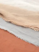 Bufanda rectangular de color negro con estampado abstracto y flecos cortos en los extremos.