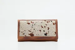 Billetera tríptica de cuero genuino en tono terracota con efecto desgastado. Cuenta con múltiples ranuras para tarjetas, un compartimento transparente para identificación y cierre con broche a presión.