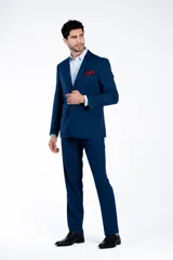 Ambo de corte slim fit compuesto por saco de dos botones con solapa clásica y pantalón de vestir a juego, en color azul con textura sutil.