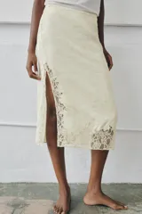 Falda midi de tiro medio color beige en tejido de viscosa con estampado jacquard y aplicación de encaje a tono en el bajo, con cierre lateral de cremallera oculta.
