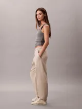 Pantalón de felpa de Calvin Klein de corte relajado, color beige, con cintura elástica ajustable con cordón, bolsillos laterales y puños elásticos en los tobillos.