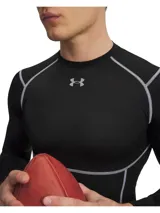 Remera térmica deportiva Under Armour HeatGear Elite Compression de manga larga, color negro con costuras planas en contraste gris claro. Cuenta con ajuste de compresión, cuello redondo y el logo de la marca estampado en el pecho.