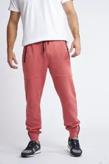 Jogging de corte slim, color coral, con bolsillos laterales con cierre, puños con cierre y cordón ajustable en la cintura.