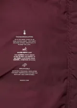 Campera acolchada de corte recto y diseño puffer, color bordó. Cuenta con capucha, cuello alto, cierre frontal de cremallera doble y dos bolsillos laterales con cierre. Presenta mangas largas con puños elásticos y acabado repelente al agua.