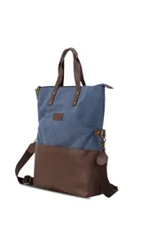 Cartera tipo tote bag combinada en tela canvas azul y base de cuero sintético marrón. Cuenta con doble asa superior, correa larga ajustable y extraíble, cierre principal y compartimento interno para notebook de 15 pulgadas.