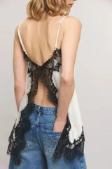 Top de satén blanco de corte regular, con breteles finos regulables y detalles de encaje negro estilo chantilly en el escote y el ruedo.