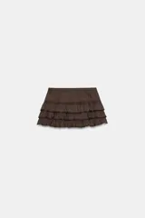 Shorts tipo pollera marrón de tiro medio, con cintura ajustable con cordones, diseño de múltiples volantes en capas y detalles de encaje a tono.