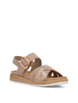 Sandalias de mujer color beige, con tiras cruzadas en la parte frontal, una de ellas con textura metalizada, y tira ajustable al talón con hebilla. Posee suela de plataforma con detalle estilo yute.
