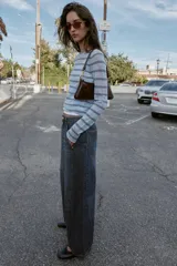 Jeans de tiro alto con corte balloon y pernera holgada. Presenta diseño de cinco bolsillos, cierre frontal con cremallera y botón, y detalle de costuras marcadas en el delantero y la espalda.