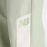 Pantalón deportivo New Balance, color verde menta, de corte holgado con cintura elástica y puños ajustados. Presenta paneles laterales en color crema con el logo de New Balance bordado en la parte inferior de la pierna.