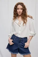Short de jean blanco de tiro medio con silueta relajada y detalle de ruedo desflecado con flecos.