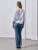 Blusa blanca de algodón marca Dash, con escote en V, abertura con botones, mangas 3/4 regulables con presilla y ruedo anudado.