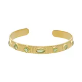 Brazalete rígido dorado con peridotos facetados de diferentes formas.