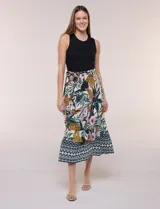 Vestido midi combinado de la marca Figueroa & Flower, con torso de modal azul sin mangas y cuello redondo, y falda evasé de rayón con estampado floral y paisajes en tonos blancos y azules, con cintura elastizada y lazo para anudar.